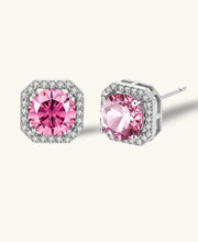 Pink moissanite studs in octagonal sterling silver halo settings with sparkling accent stones on cream background.